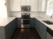 Finished kitchen with blue cabinets and white countertops