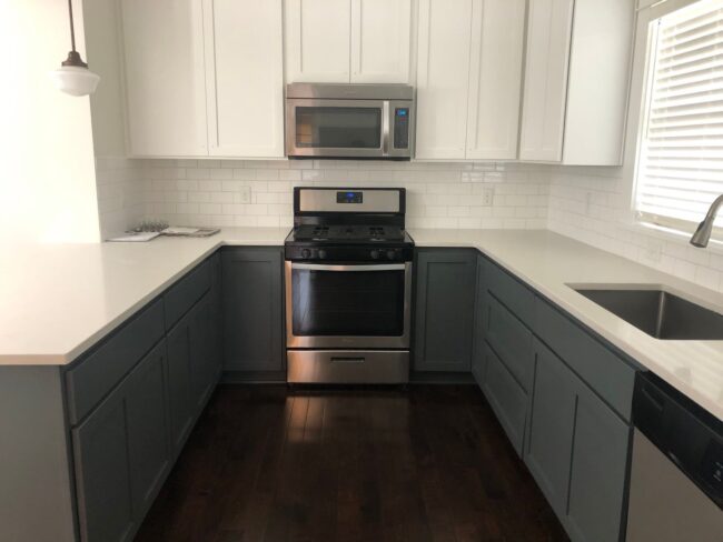 Finished kitchen with blue cabinets and white countertops