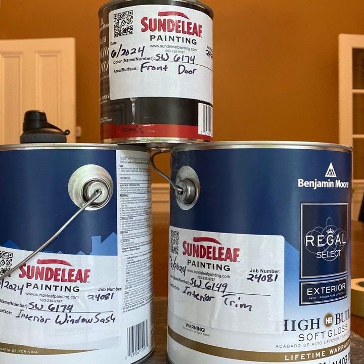 Pile of interior paint cans with Sundeleaf Painting sticker tags