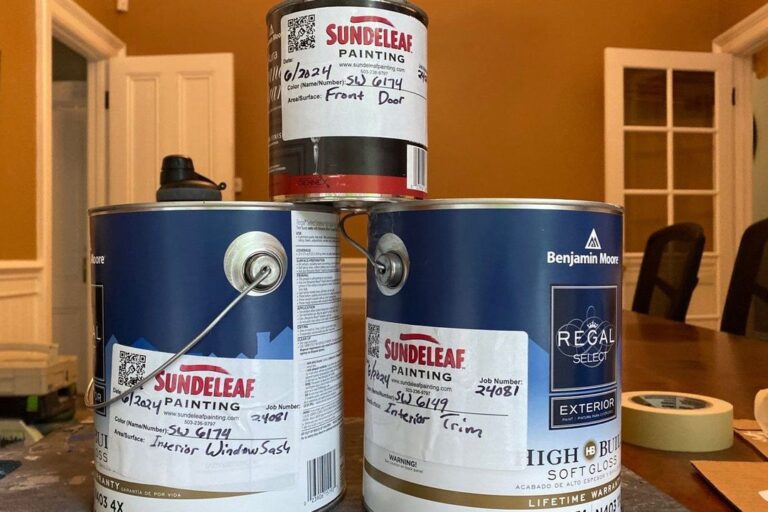 Pile of interior paint cans with Sundeleaf Painting sticker tags