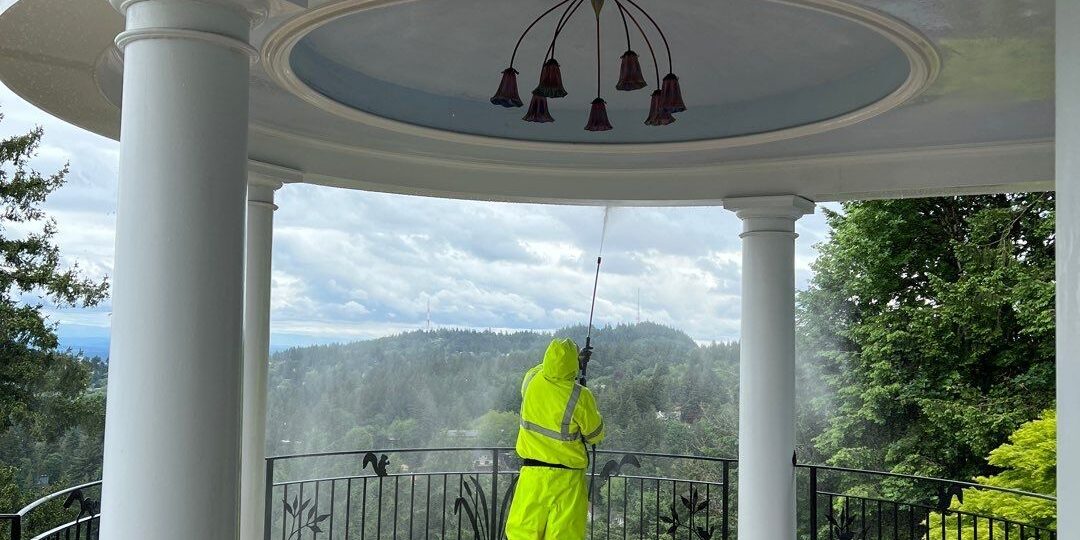 Sundeleaf Painting team member pressure washing a porch ceiling