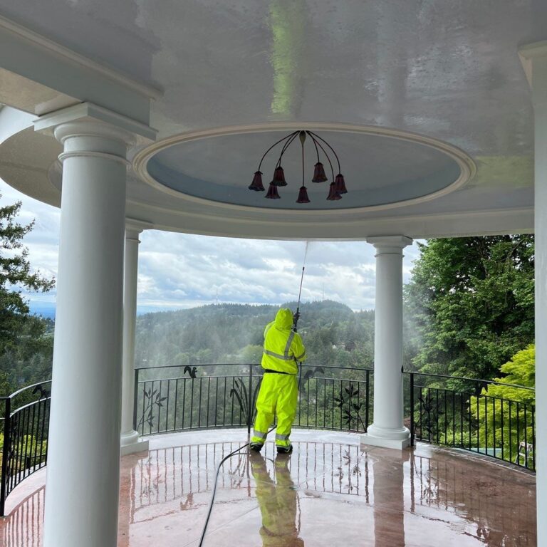 Sundeleaf Painting team member pressure washing a porch ceiling