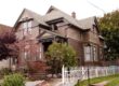 Older House With Brown Details And White Picket Fence