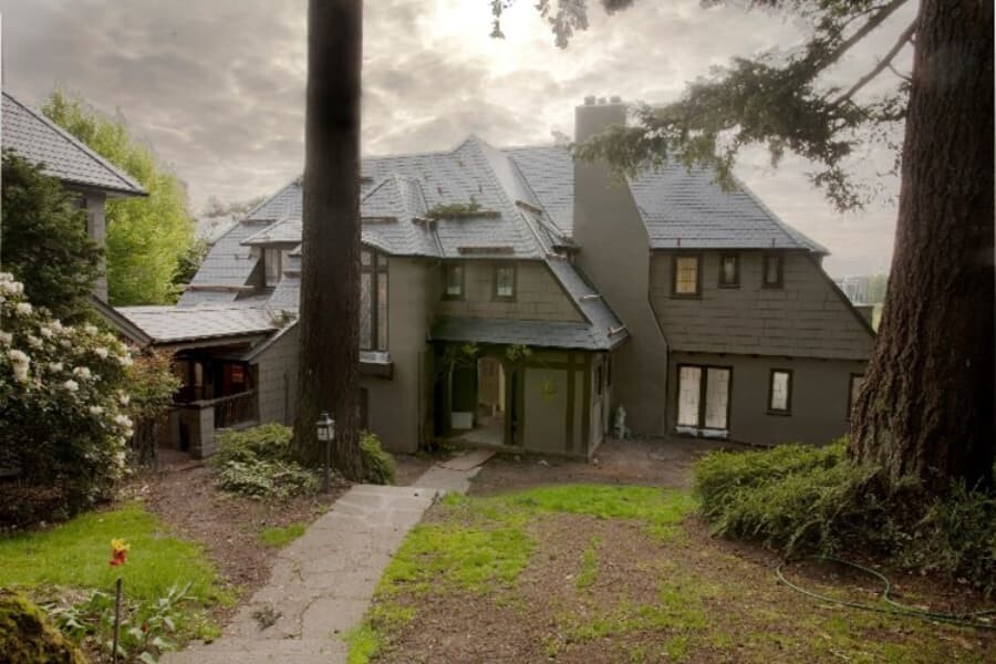 Large Green House With Yard And Trees Surrounding It
