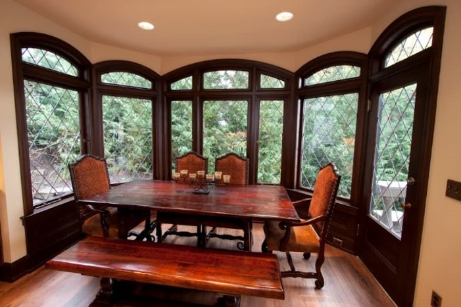 Dining Room Area With Ornate Windows And Table Set
