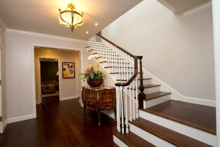 Entryway And Staircase With White Paint And Brown Railing