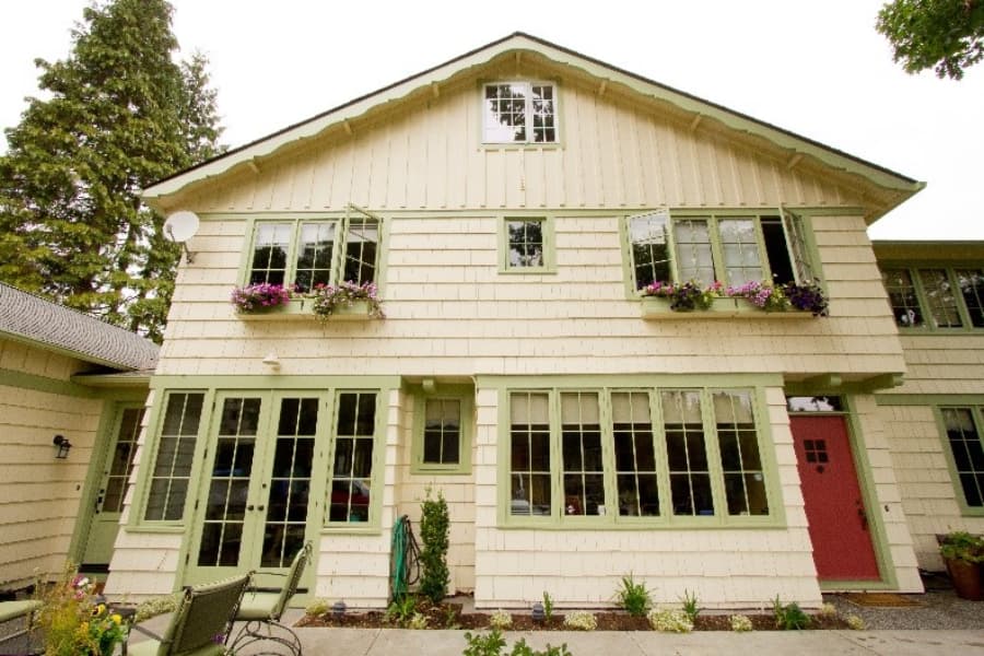 Light Yellow House With Green Shutters And Door Frames