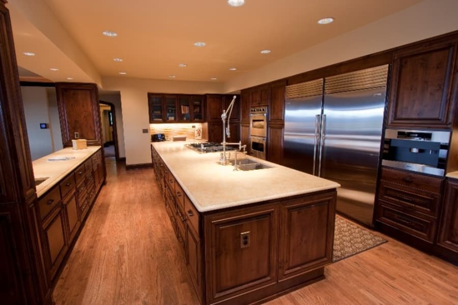 Modern Kitchen With Island, Large Refrigerator And Brown Cabinets
