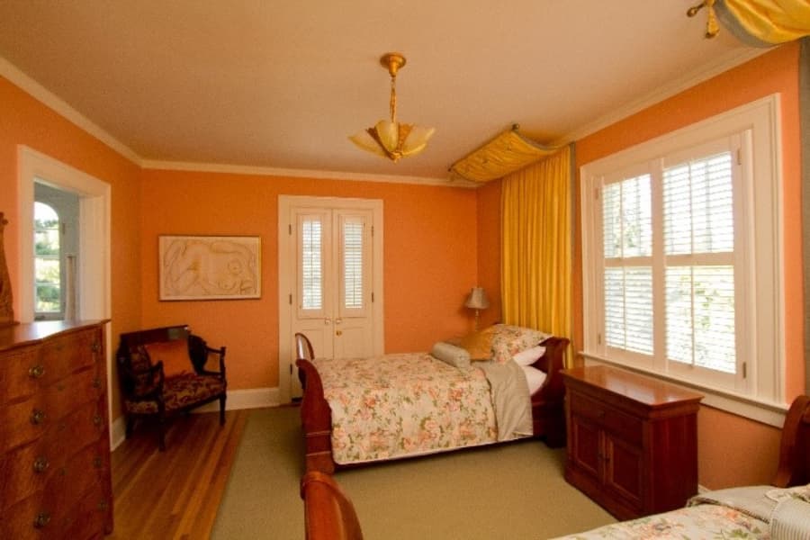 Salmon Colored Bedroom With Two Beds And Matching Furniture