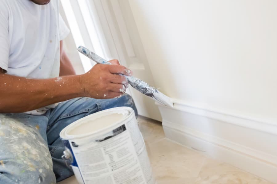 Professional painter painting wood baseboard trim