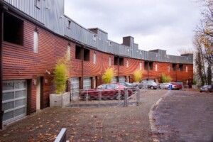 Apartment Building With Wood Siding And Cars Parked Out Front