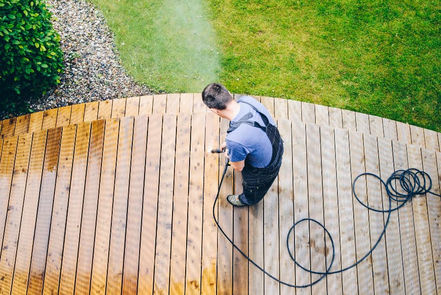 Worker With Power Washer Cleaning Off Deck Worker With Power Washer Cleaning Off Deck
