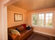 Living Room Interior With Yellow Paint And Brown Couch